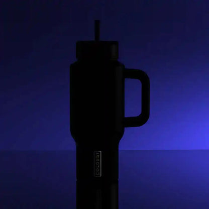 Black insulated travel mug with handle and straw, 'BOLDEST' logo, against blue gradient background