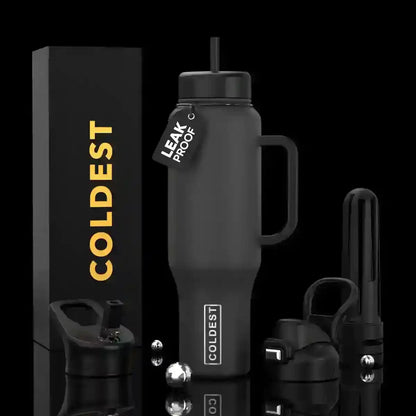 Coldest leak-proof black insulated tumbler with handle, straw, and accessories on reflective surface